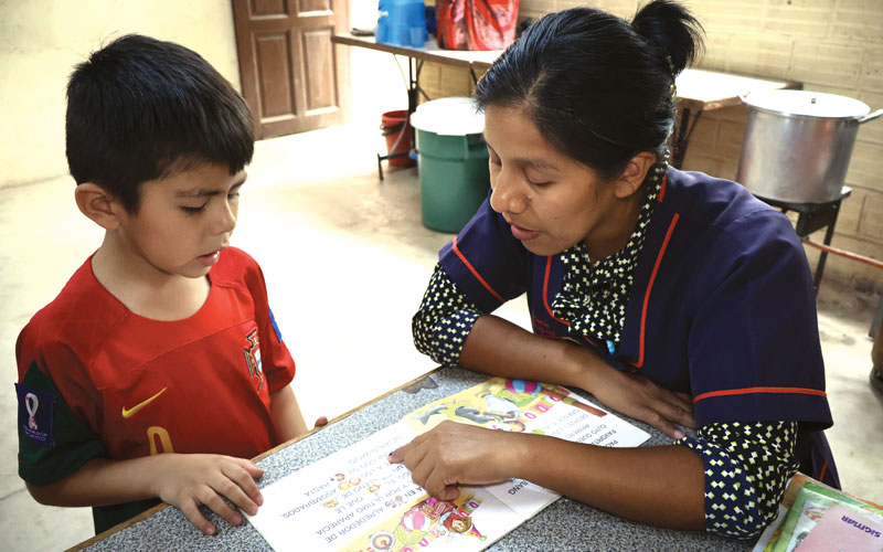 W25-sykora-escolar-2 Facilitator Beatriz Beltrán patiently teaches first-grader Ezequiel to read. (Adam Mitchell/Bolivia)