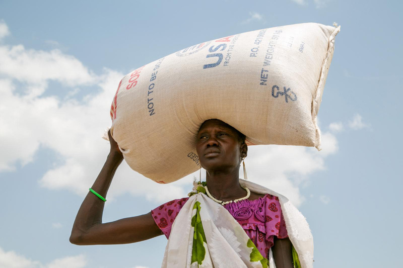 AID SOUTH SUDAN A woman carries food provided by U.S. Agency for International Development in Pajut, South Sudan, March 17. Catholic Relief Services is providing food assistance, with USAID funding, to communities and people who are returning to the area after being displaced during violence in 2013. (CNS photo/Nancy McNally, Catholic Relief Services) See SOUTH-SUDAN-CRS March 21, 2017.