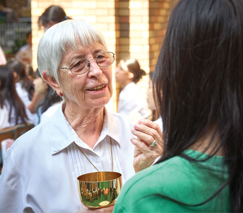 Maryknoll Sister Susan Glass, MCS spiritual advisor, gives Communion to a secondary section student during an All Saints Day Mass held at Maryknoll Convent School. (Paul Jeffrey/Hong Kong)