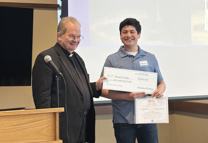 Maryknoll Father Kevin Hanlon presents Daniel Cobio with the Bishop Francis X. Ford Award for Division I at Holy Family Catholic Church, the Cobio family’s parish. (Courtesy of Holy Family Catholic Church/U.S.)