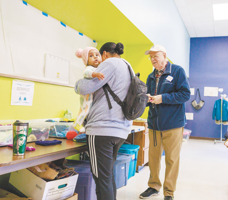 The center offers a wide range of support services, thanks to generous donors and many dedicated volunteers such as Gary Jacobs, seen here helping a migrant mother and child. (Octavio Durán/U.S.)