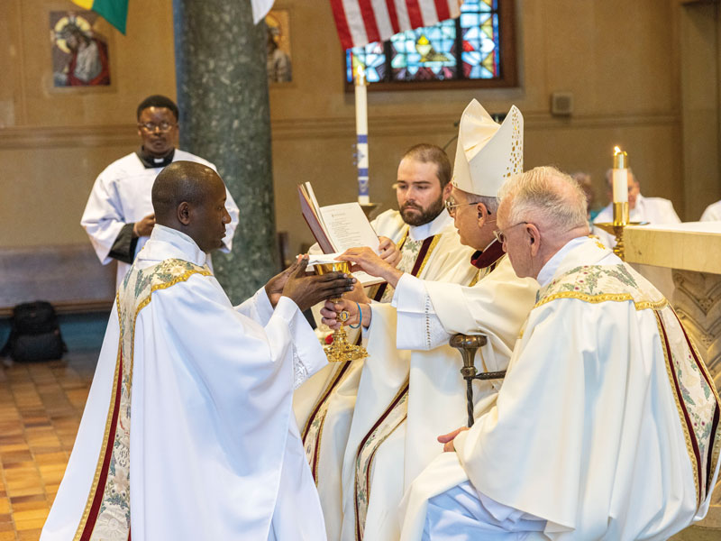 F25-Ordination-1 Bishop Mark J. Seitz of El Paso, Texas, presents a chalice and paten to Father Okok. (Octavio Durán/U.S.)