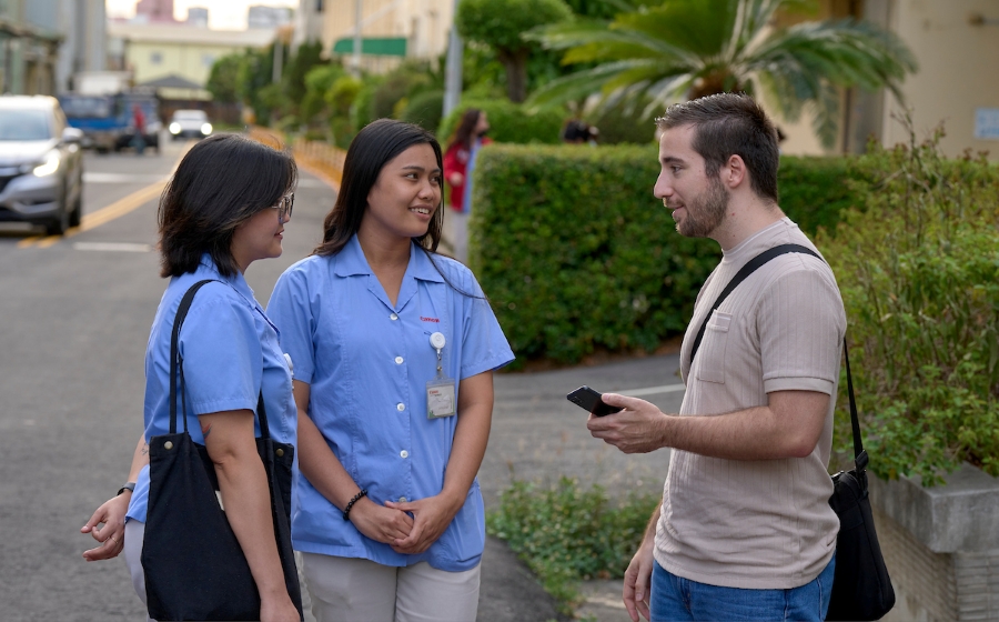 Charles Niece, the director of human rights and supply chain transparency, a Maryknoll project based in Taiwan, talks with workers as they leave work at a camera lens factory in Taichung, Taiwan.
