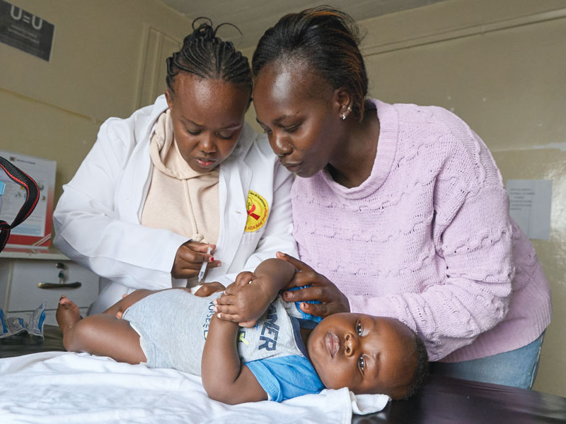 Nurse Mary Kamau vaccinates the child of an HIV-positive mother. Thanks to EDARP, transmission of the virus to all four of this mother’s children has been prevented. (Paul Jeffrey/Kenya)