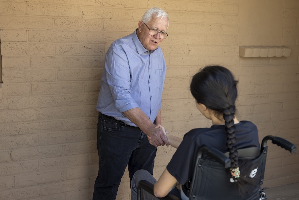Executive Director Ruben García welcomes a young migrant with disabilities at a shelter run by Annunciation House, which he founded with friends in El Paso 48 years ago to serve migrants. The nonprofit has since grown into a network of shelters. (Octavio Durán/U.S.)