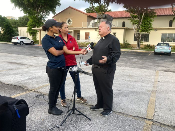 Father Juan Sosa, pastor of St. Joseph Church in Miami Beach,  near the partially collapsed condo building in Surfside, Fla., speaks to the media before the 8 a.m. Mass June 25, 2021, which was offered for victims of the collapse. Father Sosa said 10 of his parish families who lived in the building were unaccounted for, while two others had been accounted for. (CNS photo/Tom Tracy, Florida Catholic)