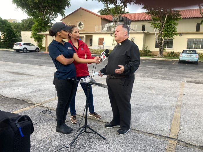 20210625T1115-MIAMI-BUILDING-COLLAPSE-1250825 Father Juan Sosa, pastor of St. Joseph Church in Miami Beach, near the partially collapsed condo building in Surfside, Fla., speaks to the media before the 8 a.m. Mass June 25, 2021, which was offered for victims of the collapse. Father Sosa said 10 of his parish families who lived in the building were unaccounted for, while two others had been accounted for. (CNS photo/Tom Tracy, Florida Catholic)